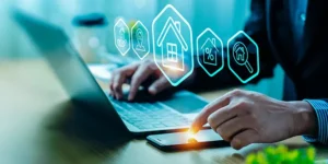 Person working on a laptop with graphic icons related to housing
