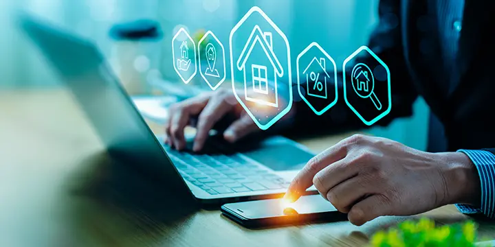 Person working on a laptop with graphic icons related to housing